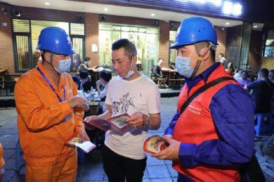 為各個攤位檢查用電安全情況、排查隱患、發(fā)放用電安全宣傳單